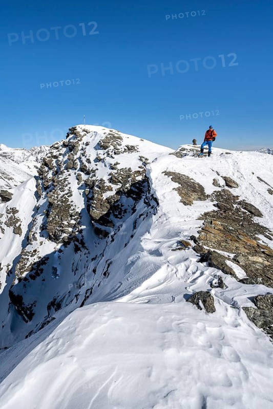 Ski tourers on foot at the summit of the Madritschspitze, snow-covered mountain landscape in winter, Ortler Alps, Vinschgau, Italy