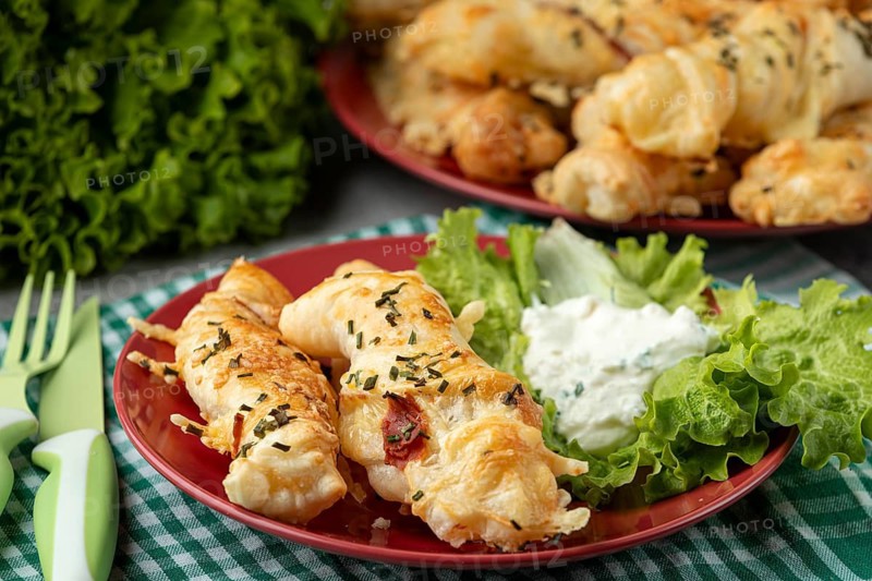 Ready baked cheese rolls with dip and salad served on a plate