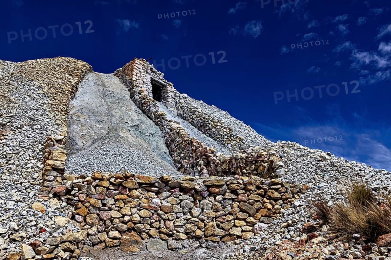 A stone structure rises against the clear blue sky in a rocky landscape, The Silver Mines near Potosi on Cerro Rico in Bolivia