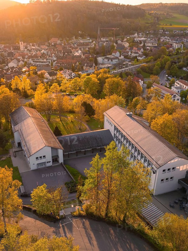 Aerial view of a building complex in an autumnal town at sunset, Nagold, Black Forest, Germany