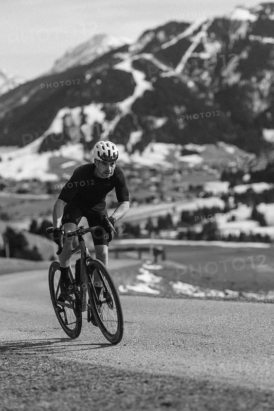 Road bike rider in spring in the Allgäu against the picturesque backdrop of the Alps, Bavaria, Germany