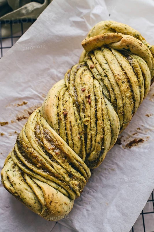 Baked homemade savoury babka plaited bread loaf flavoured with pesto