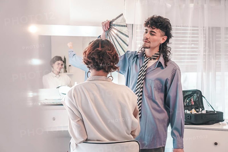 Professional makeup artist assisting a client in selecting the ideal foundation shade from a color palette for a flawless makeup application in a beauty salon