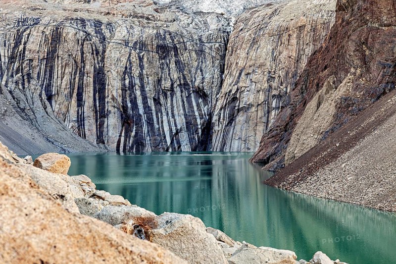 Turquoise-coloured lake with steep, layered rock faces that create a peaceful and natural environment, The glacial lake below the rock towers of Torres del Paine National Park in Patagonia Chile