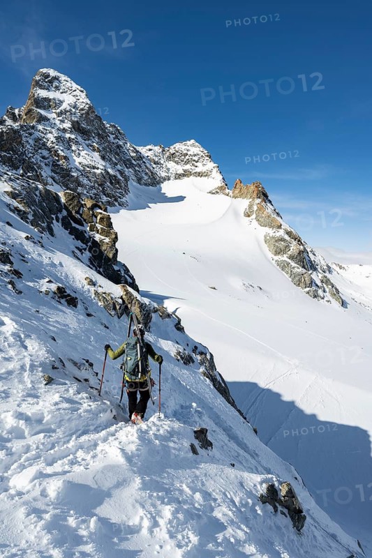 Mountaineer with skis at the fork Porta d'Es-cha, view of mountain peak Piz Kesch and glacier Vadret da Porchabella, ski tour Bündner Haute Route, Albula Alps, Rhaetian Alps, Grisons, Eastern Switzerland, Switzerland