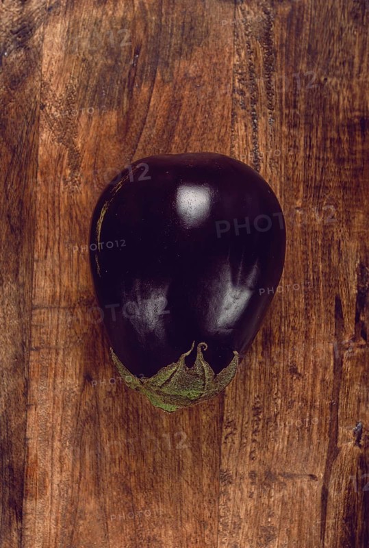Black eggplant, spherical shape, on a wooden board, top view, raw eggplant, no people