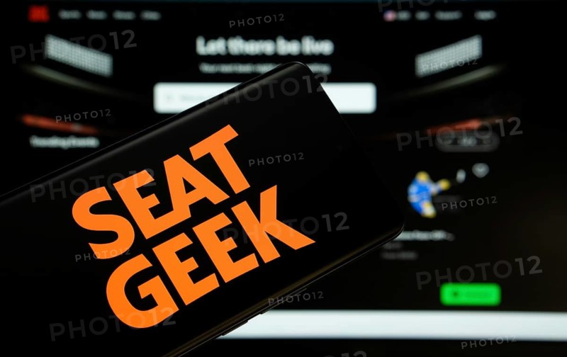 Dhaka, Bangladesh - 18 March 2025: The logo of the SeatGeek is displayed on a smartphone screen, and the website SeatGeek is visible on a computer screen in the background