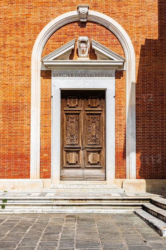 Decorated arched entrance gate in a brick façade, Pisa, Tuscany, Italy