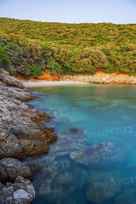 Crystal clear and turquoise water on the beach of Ustrine Bay on a sunny day at sunset on the island of Cres, long exposure, Croatia