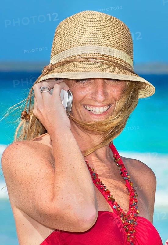 Woman on beach using smart phone, Formentera, Balearic Islands, Spain
