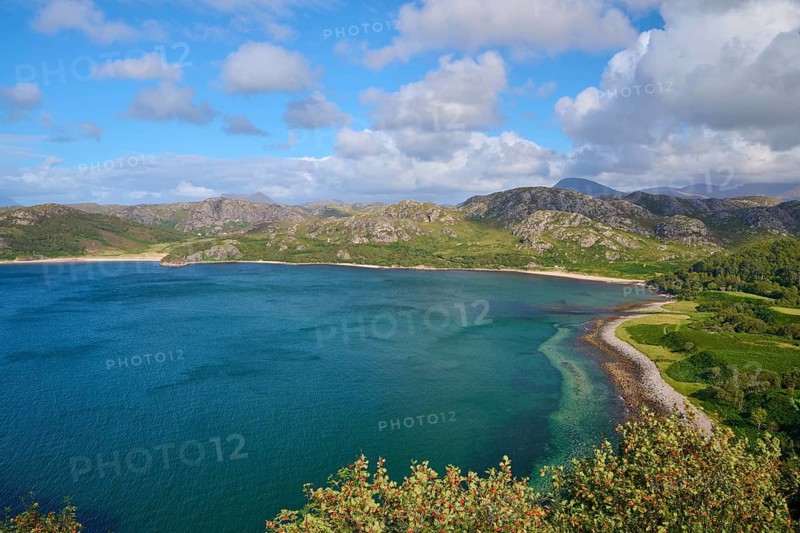 View of quiet bay surrounded by green mountains under a blue sky with white clouds, Gruinard Beach, First Coast, Little Gruinard, Achnasheen, Scotland, United Kingdom, Great Britain