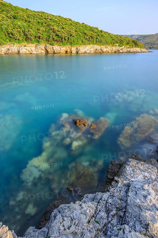 Crystal clear and turquoise water on the beach of Ustrine Bay on a sunny day at sunset on the island of Cres, long exposure, Croatia