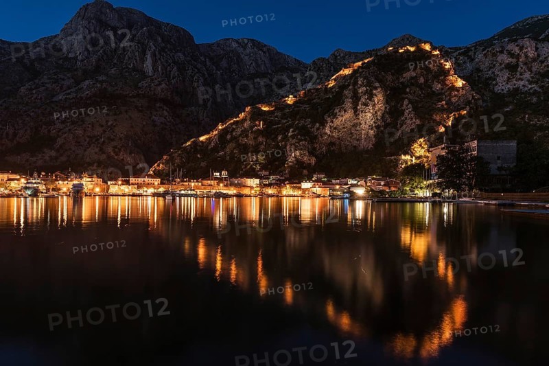 Town Kotor lights of city and reflection on a water withe the shaoe of heart during the evening, Montenegro.