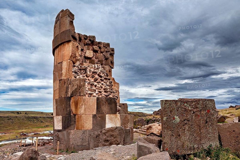 Tall, rectangular stone pillar against a dramatically cloudy sky, The Chullpas of Sillustani near Puno in Peru