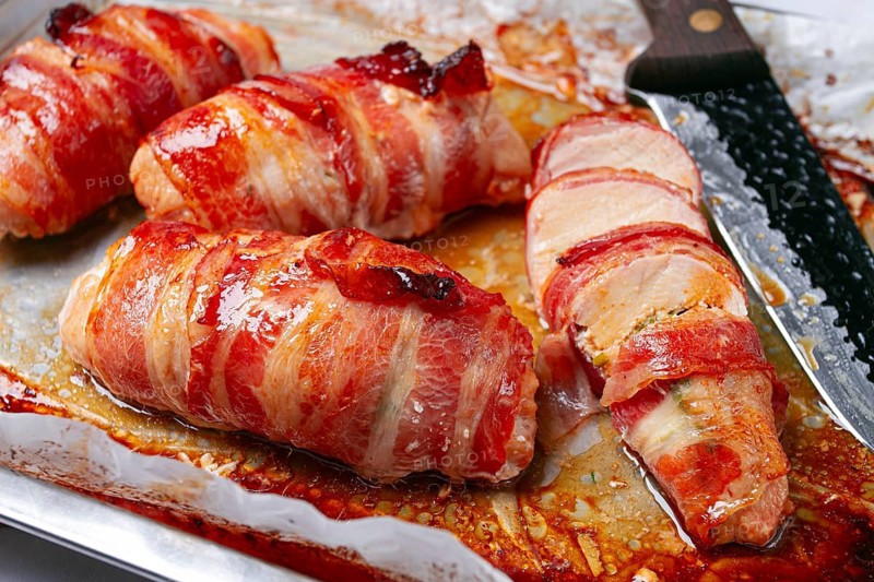 Baked chicken breast, wrapped in bacon, on a baking tray. in the home kitchen.close-up
