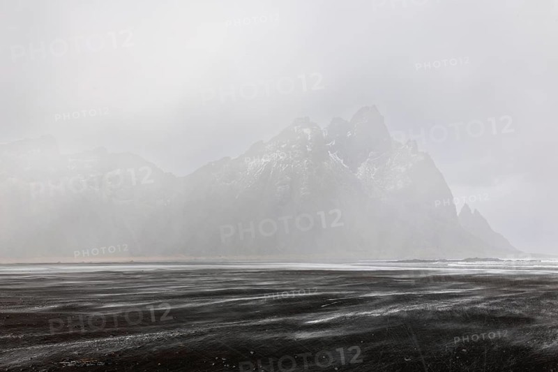 Sea waves on lava sandy beach against mountain backdrop, sleet showers, winter, Stokksnes, Vestrahorn, Klifatindur, Höfn, Iceland, Scandinavia
