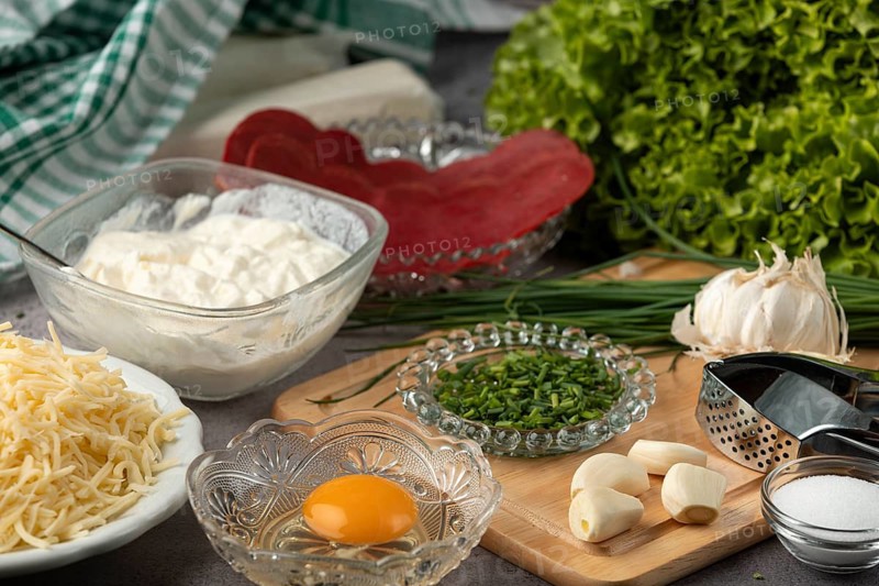 Ingredients, including puff pastry, egg, lettuce, cheese, chives, and fresh garlic