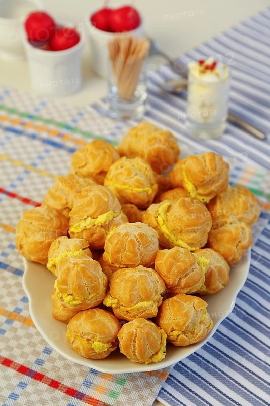 Swabian cuisine, mini cream puffs filled with goat's cream cheese, cream cheese éclairs, profiterole arranged on serving platter, shortbread, oven cakes, choux pastry, pastry, hearty, salty, choux pastry, baked, from the oven, vegetarian, bake, from the oven, typical Swabian reinterpreted, party pastry, finger food, appetisers for on the go, traditional cuisine reinterpreted, food photography, studio, Germany