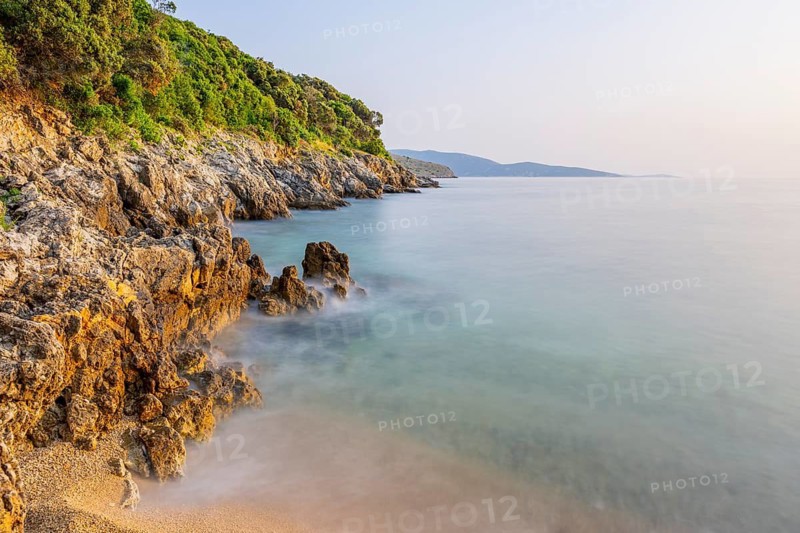 Crystal clear and turquoise water on the beach of Ustrine Bay on a sunny day at sunset on the island of Cres, long exposure, Croatia