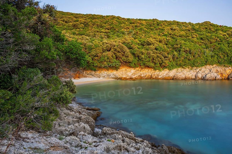 Crystal clear and turquoise water on the beach of Ustrine Bay on a sunny day at sunset on the island of Cres, long exposure, Croatia