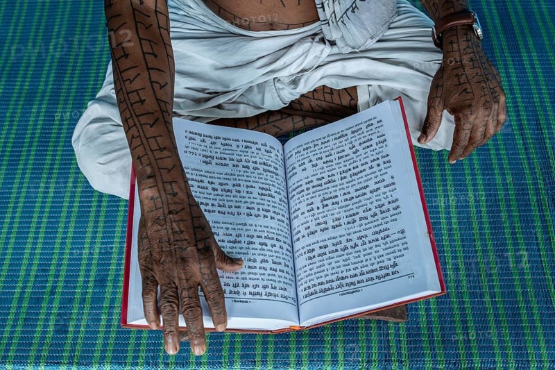 Man from the Ramnami community reading the Ram Charit Manas, the holy book of the Ramnamis (Chhattisgarh, India), As a sign of devotion, Ramnami people used to tattoo their body and face with the name of Rama, one of the main hindu god. Nowadays, this tradition is disappearing. Indeed, few of them are still tattooed, the younger generation fearing discrimination. The community (or sect) is born in the end of the 19th century as a way to protest against the supremacy of the higher classes in the hindu hierarchical system