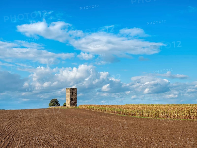 The Blue Tower in a ploughed field in autumn, medieval watchtower in the Magdeburger Börde, blue sky with dramatic clouds, Wanzleben-Börde, Saxony-Anhalt, Germany