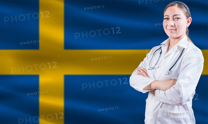 Female doctor on Swedish flag. Doctor with crossed arms on Swedish flag. Sweden health and care concept