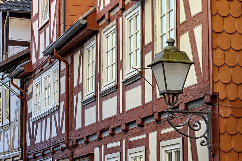 Traditional half-timbered house façade with lantern in red-brown and white colours, windows in the façades of old half-timbered houses in Spangenberg
