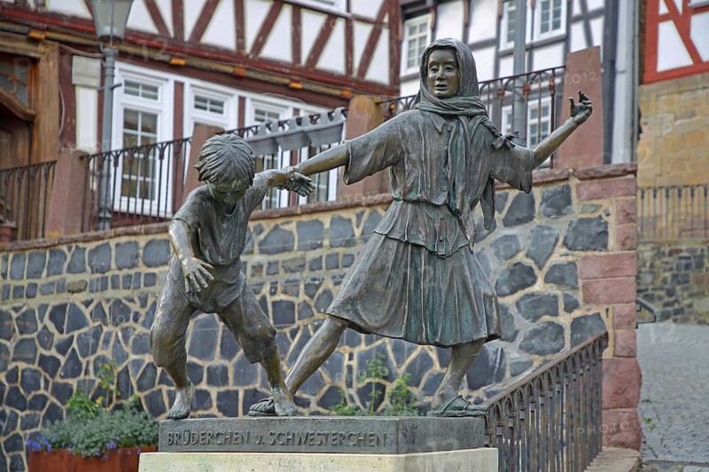 Brother and Sister sculpture by Ewald Rumpf 1997, two fairytale characters, modern art, bronze sculptures, life-size, boy and girl dancing, moving, inscription, Deutsche Märchenstraße, Marktplatz, Homberg-Efze, Hesse, Germany