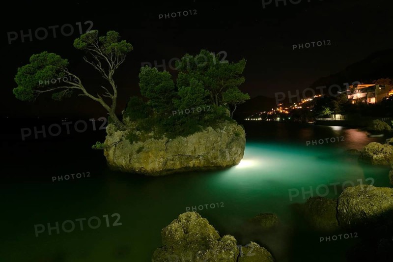 Rock island with illumintaion at night in Brela, Croatia