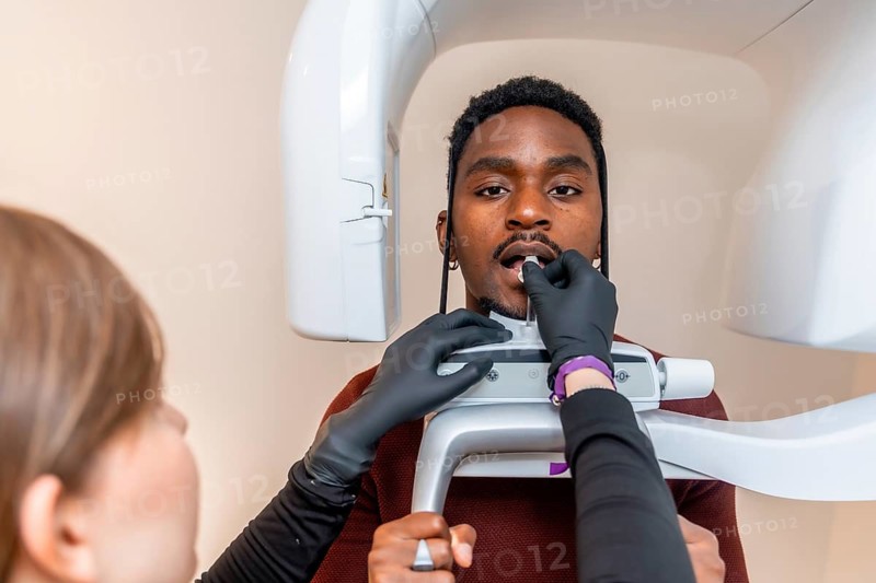 Dentist preparing a patient for a dental panoramic radiograph, ensuring accurate diagnosis and treatment planning in a modern dental clinic