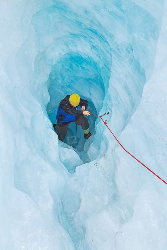 Mountaineer moving up ice cave, Fox Glacier, Westland National Park, South Island, New Zealand