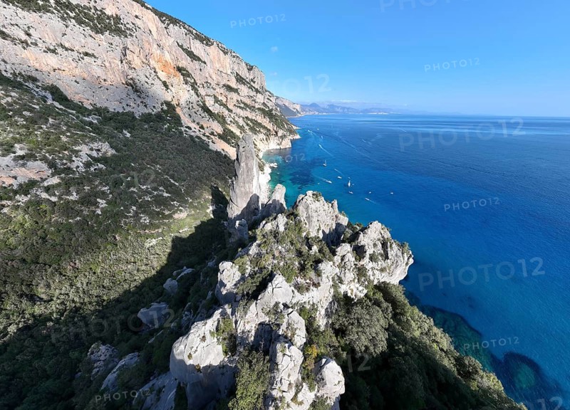 Picturesque rocky coast, cliffs with L'Aguglia pinnacle, blue sea and Cala Goloritzé beach, aerial view, Golfo di Orosei, Baunei, Sardinia, Italy