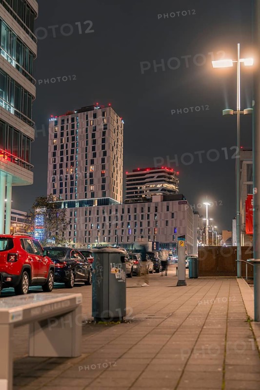 Urban scenery with illuminated skyscrapers and parked cars at night, Stuttgart, Germany