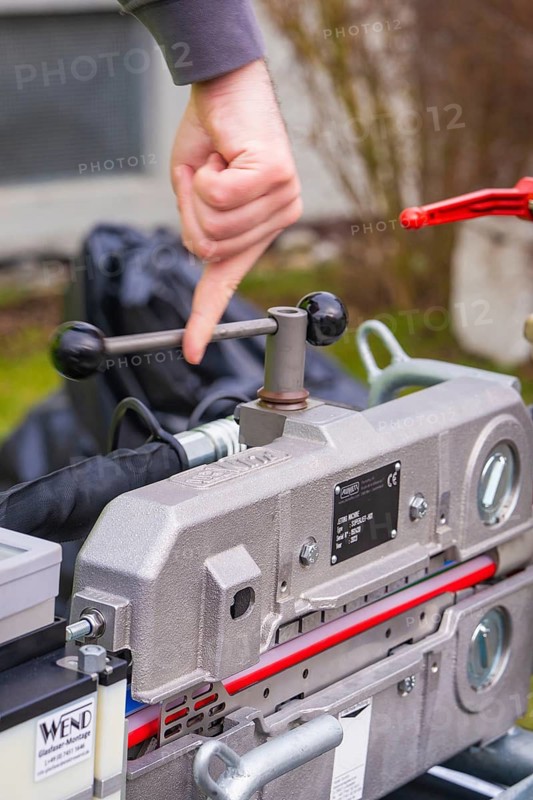 Person operating mechanical device in close-up, Wend Glasfasermontage during the jetting of conduits for fibre optic cables, Meßkirch, district of Sigmaringen, Germany
