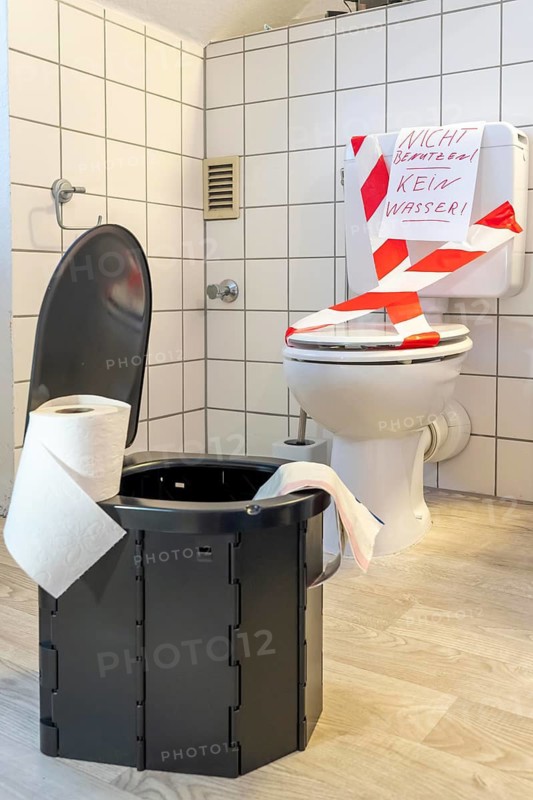 Symbolic picture blackout, extensive, prolonged power failure, in private environments, without electricity, the water supply also fails, toilet flush no longer works, emergency toilet, mobile toilet, camping toilet as an emergency replacement, disposal in bags