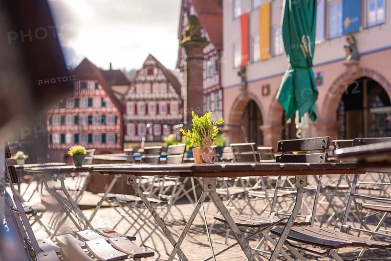 Sun-drenched table with Easter decoration in front of half-timbered houses on a market square, Calw, Black Forest, Germany