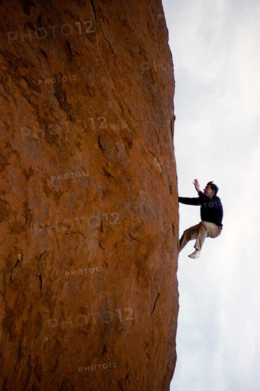 Expedition of the Melbourne Grammar School, Northern Territory, Australia, 1956: A boy pretends to climb up the vertical slope of Ayers Rock, Uluru