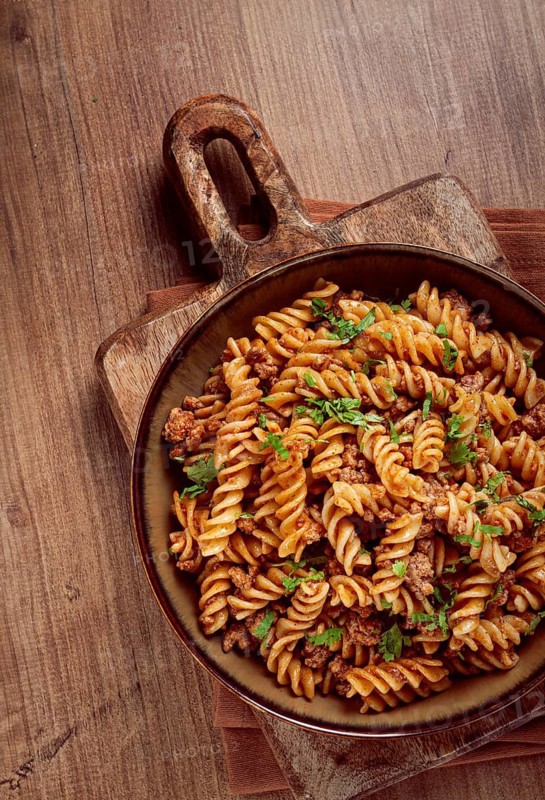 Pasta in the navy, pasta with minced meat, plate on a wooden table, homemade, fusilli pasta, without people