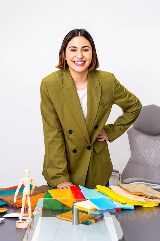 A professional woman of image consultant offers expert fashion advice, showcasing various fabric options for optimal personal styling. The consultant stands confidently, exemplifying style tips