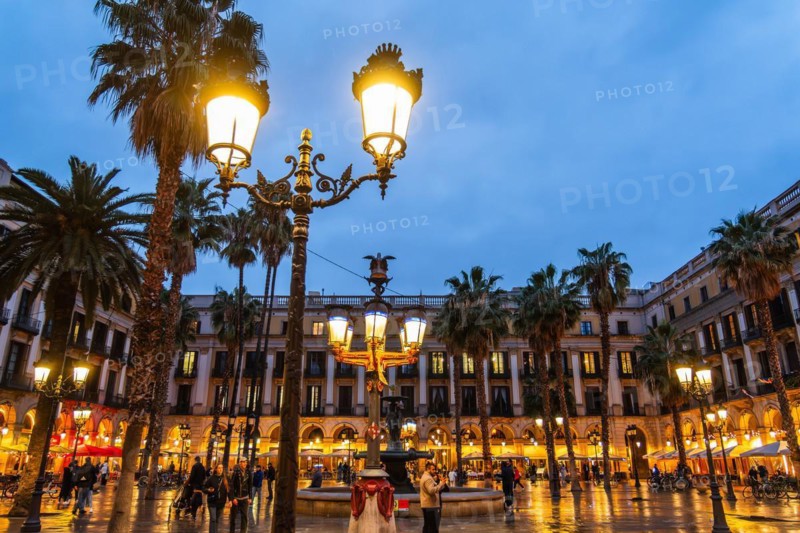 Nightlife at Plaça Reial, lanterns by Gaudi in the historic centre of Barcelona, Spain