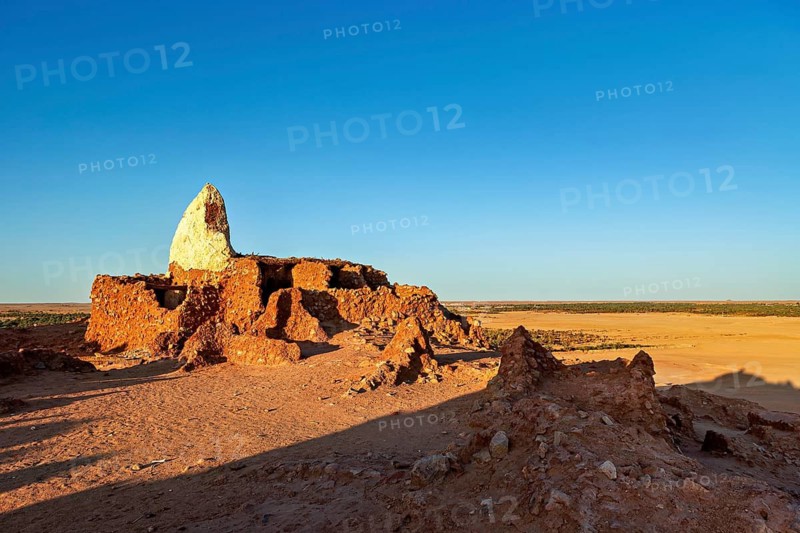 Ancient ruins in a vast desert landscape under a clear blue sky, An old cemetery in the Sahara in Algeria