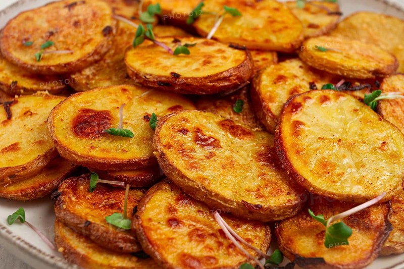 Crispy potato slices, with parmesan cheese and spices, fried in the oven, homemade, no people