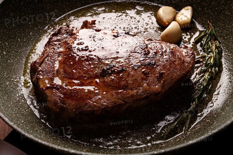 Fried steak, beef steak, rib eye steak, in a frying pan, top view, no people