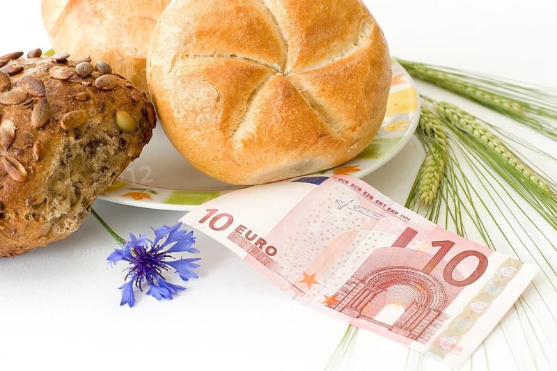 Various rolls with a 10-euro note and ears of grain, wholemeal rolls, an expensive breakfast, studio, Hesse, Federal Republic of Germany