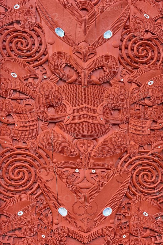 Close-up of a symmetrical Maori wood carving with red decorations, New Zealand Maori Arts and Crafts Institute, Te Puia, Whakarewarewa, Rotorua, North Island, New Zealand