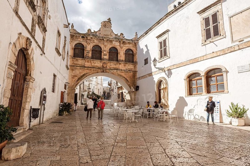 OSTUNI, ITALY - SEPTEMBER 26, 2018: Tourists in Arco Scoppa of Ostuni, La Citta Bianca (The White Town) Apulia, Italy