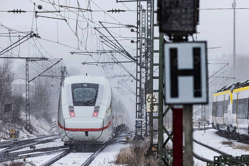 ICE traveling through a winter landscape in snowfall. A train on the line in the Deutsche Bahn Amstetten rail network, Baden-Württemberg, Germany
