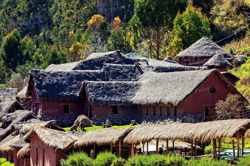 Traditional clay huts with thatched roofs in an autumn landscape surrounded by green trees, village with traditional houses in the Andes of Peru