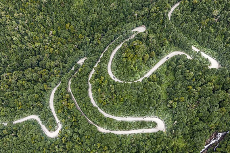 Aerial view of a winding road (Carretera Austral) through dense forest, south of Puyuhuapi, Aysén Region, Chile
